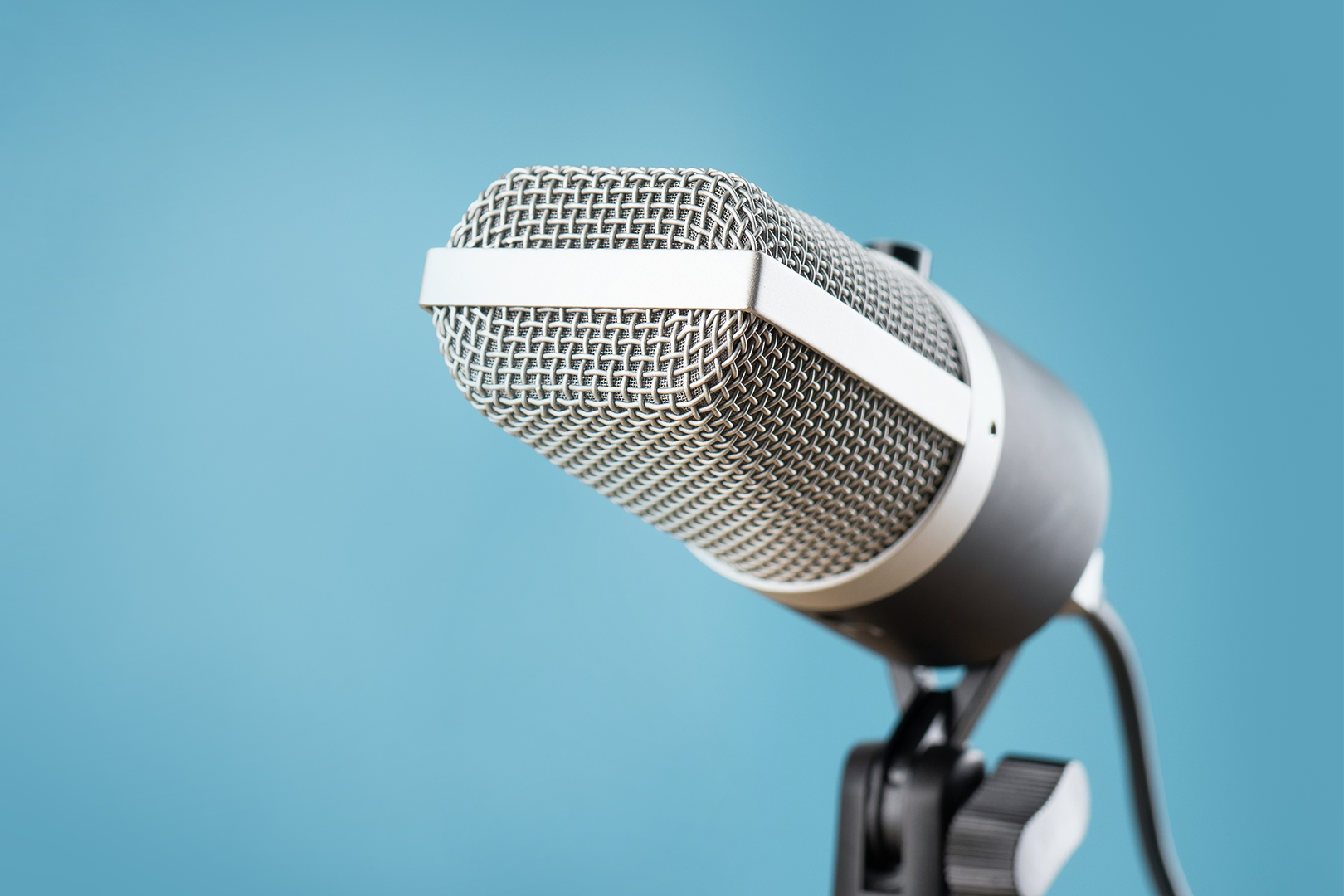 A microphone in front of a blue background