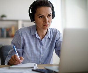 woman studying in front of laptop with headphones on